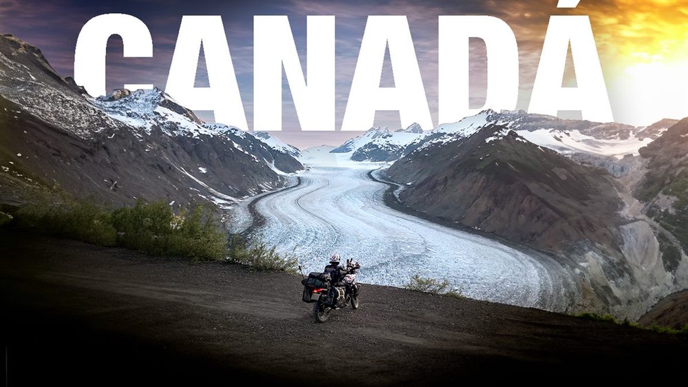 Glaciar serpenteando entre montañas en Canadá, con la moto en primer plano