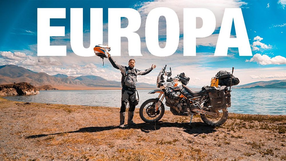 Andrés con la moto al borde de un lago de montaña — Europa, el inicio del viaje
